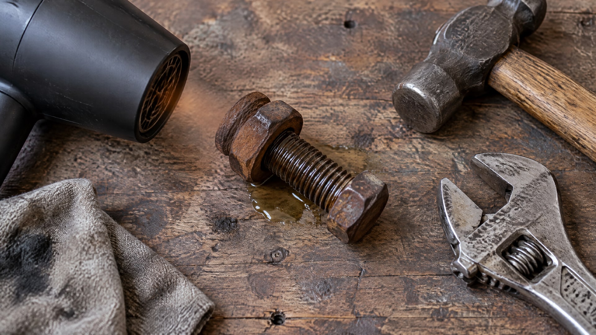 Нагревание закисшей гайки феном для проникновения WD40, с гаечным ключом и молотком.