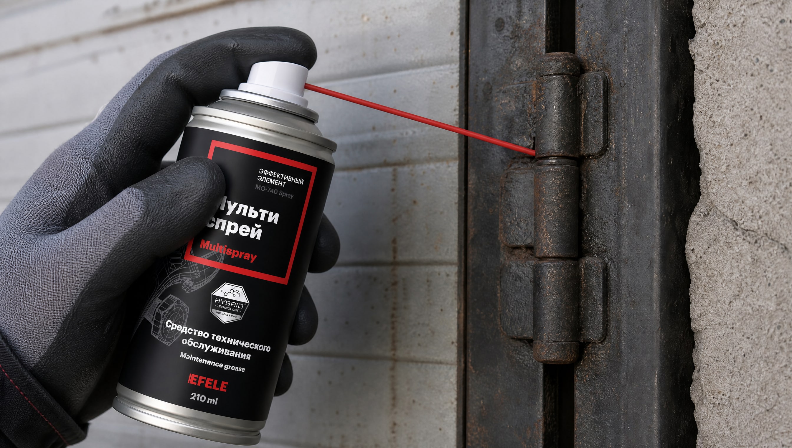 Рука в перчатке наносит EFELE MO-740 Spray, чтобы смазать гаражные ворота.